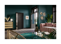 Stilvolles Wohnzimmer mit smaragdgrünen Wänden, schwarzer Tür, rosa Sofa und goldenen Akzenten