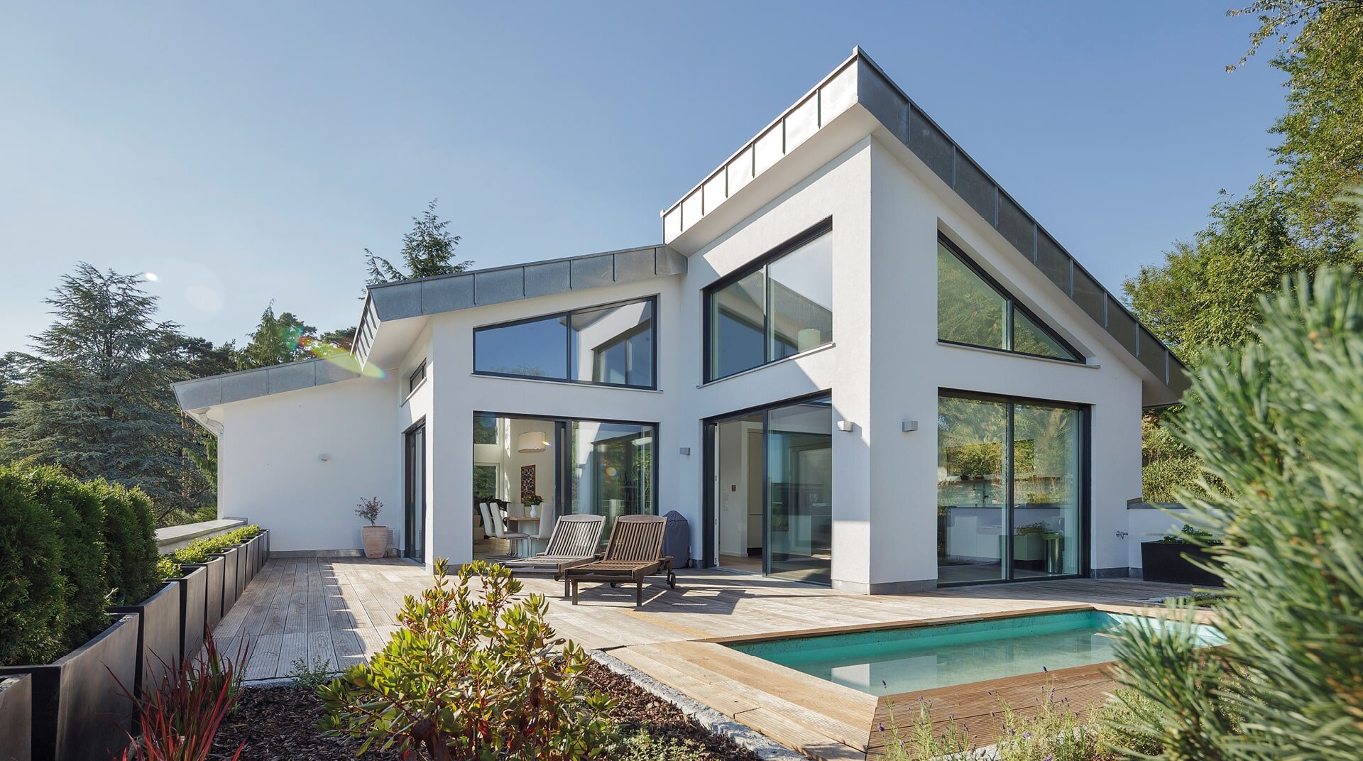 Satteldach Landhaus 290, weißes Haus hinter Pool, von außen