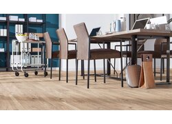 Büro mit großem Tisch und Stühlen.